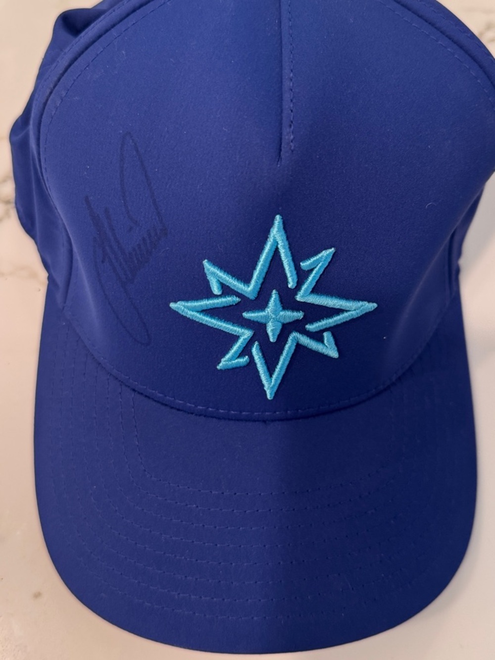 Live golf with Authograf Blue Trucker Hat with Teal Starburst Embroidery